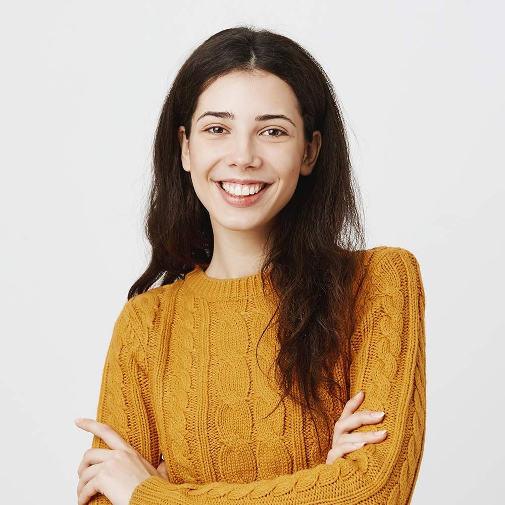 smiling-woman-in-yellow-sweater-against-white-back-2026-01-05-05-45-58-utc